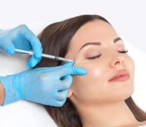 A woman getting a toxins injection in her cheek.